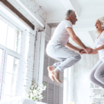 3 Healthy Home Hacks | Grandparents jumping on a bed enjoying retirement in their mold free home
