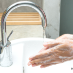 Are We Over-Cleaning Our Skin? | Soapy hands over a bathroom sink